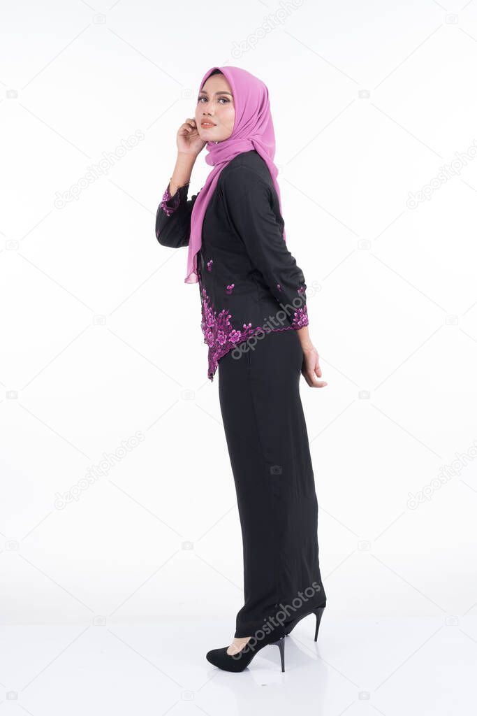 Beautiful female model in kebaya and hijab, a modern lifestyle apparel for Muslim women isolated on white background. Beauty and hijab fashion concept. Full length portrait