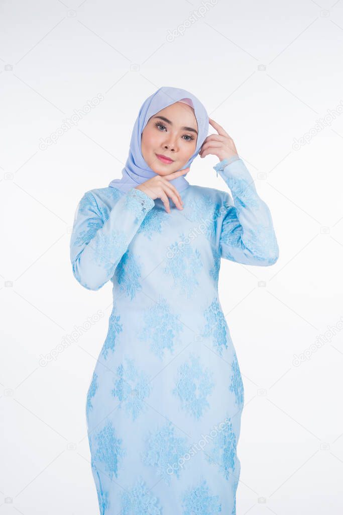 Beautiful Muslim female model wearing pastel blue modern kurung with hijab, a urban lifestyle apparel for Muslim women isolated on white background. Beauty and hijab fashion concept. Half length