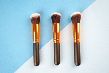 Kozmetik ürünleri pastel mavi arka planda yaratıcı bir şekilde düzenlenmiştir. Düz ya da üst görünüm. Kozmetik ya da güzellik uzmanı konsepti