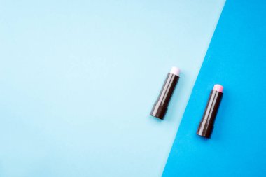 Kozmetik ürünler pastel renkli arka planda, düz görünümde yaratıcı bir şekilde düzenlenmiştir. Minimalizm kavramı.