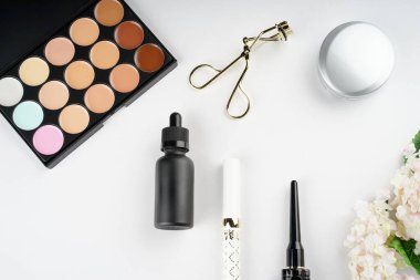 Kozmetik ürünleri, beyaz arka planda izole edilmiş bir şekilde yaratıcılıkla düzenlenmiştir. Düz ya da üst görünüm. Kozmetik ya da güzellik uzmanı konsepti