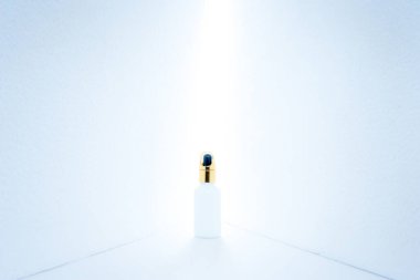 Minimalist bir konseptte kozmetik ürün tanıtımı. Merkeze yerleştirilen ürünler arasında bir boşluk bulunan açılı duvarlar ve boşluktan parlak bir ışık parlıyordu. Soğuk, soğuk bir ton..