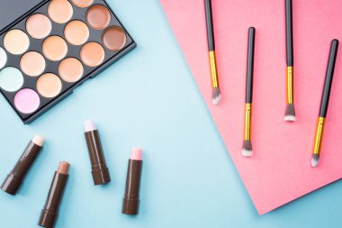 Kozmetik ürünler pastel renkli arka planda, düz görünümde yaratıcı bir şekilde düzenlenmiştir. Minimalizm kavramı.