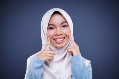 Gri arka planda izole edilmiş çeşitli yüz ifadelerini gösteren tesettürlü şirin bir müslüman gencin vesikalığı. Peyzaj yönelimi.