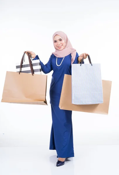 一位漂亮的穆斯林女模特 身穿亚洲传统服装 背着白色背景的购物袋 我有一个节日准备购物的概念 全长肖像 — 图库照片