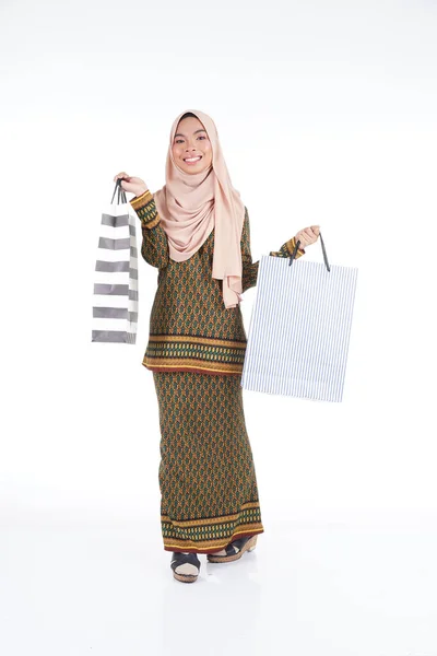 一位漂亮的穆斯林女大学生身穿亚洲传统服饰 穿着现代和服 背着白色背景的购物袋 Eidul Fitri时尚和节庆购物理念 — 图库照片