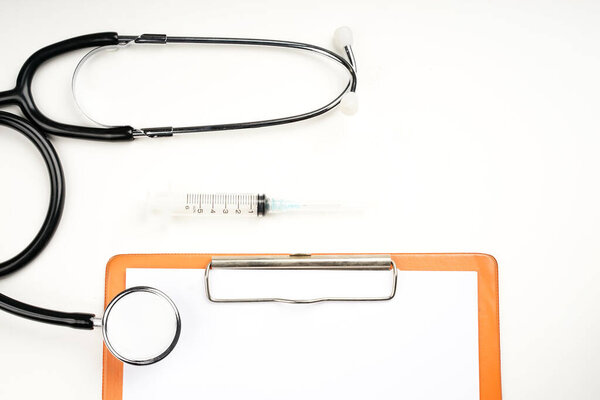 Stethoscope and doctor's note pad isolated on white background