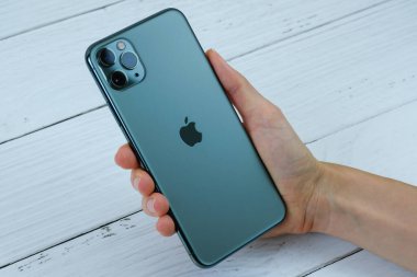 iPhone 11 Max Pro gece yarısı yeşil renginde bir müşteri tarafından tutuluyor