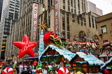 Noel Baba, Macy 'nin Şükran Günü geçit töreninde arka planda Radyo Müzik Salonu olan Amerika Bulvarı boyunca. Manhattan, New York, ABD - 27 Kasım 2014.