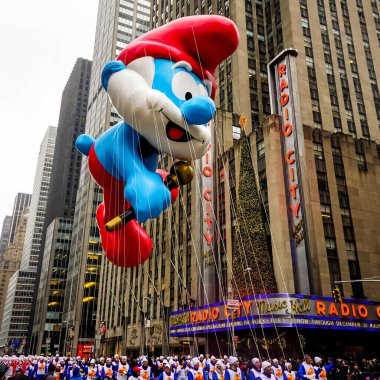 Şirin Baba balonu Macy 'nin Şükran Günü geçit töreninde havada süzülüyor. Arka planda Radyo Müzik Salonu var. Manhattan, New York, ABD - 27 Kasım 2014.