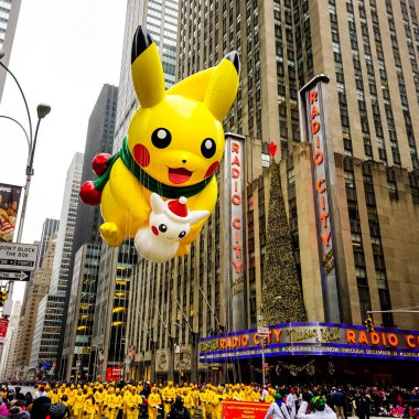 Pikachu pokemon balonu, Macy 'nin Şükran Günü geçit töreni sırasında havada süzülür. Arka planda Radio Music Hall ile birlikte Amerika Bulvarı boyunca. Manhattan, New York, ABD - 27 Kasım 2014.