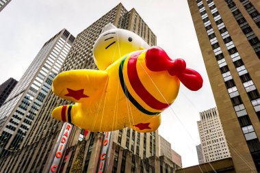 Hello Kitty balonu, Macy 'nin Şükran Günü geçit töreni sırasında havada süzülür. Arka planda Radio Music Hall ile birlikte Amerika Bulvarı boyunca. Manhattan, New York, ABD 27 Kasım 2014
