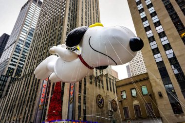Snoopy balonu her yıl düzenlenen Macy 'nin Şükran Günü geçit töreninde havada süzülüyor. Arka planda Radyo Müzik Salonu var. Manhattan, New York, ABD - 27 Kasım 2014.