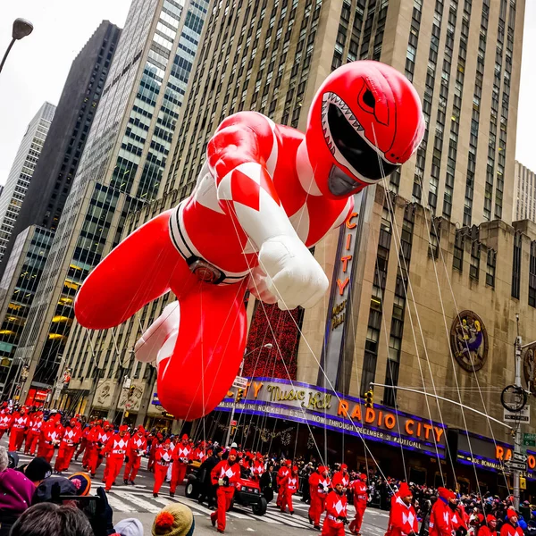 パワー レンジャーの気球は メイシーの感謝祭の日のパレードの間に バックグラウンドでラジオ音楽ホールと共にアメリカ大陸のアベニューに沿って空中に浮かびます 2014年11月27日米国ニューヨーク州マンハッタン — ストック写真