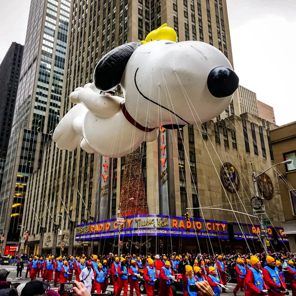 Snoopy balonu her yıl düzenlenen Macy 'nin Şükran Günü geçit töreninde havada süzülüyor. Arka planda Radyo Müzik Salonu var. Manhattan, New York, ABD - 27 Kasım 2014.
