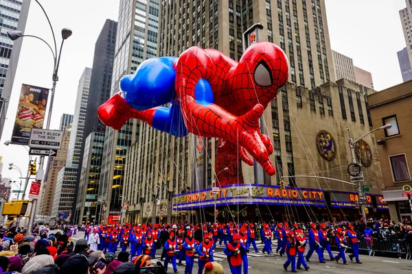 スパイダーマン気球は バックグラウンドでラジオ音楽ホールとアメリカのアベニューに沿って毎年のメイシーの感謝祭のパレード中に空気中に浮かぶ 2014年11月27日 ニューヨーク州マンハッタン — ストック写真