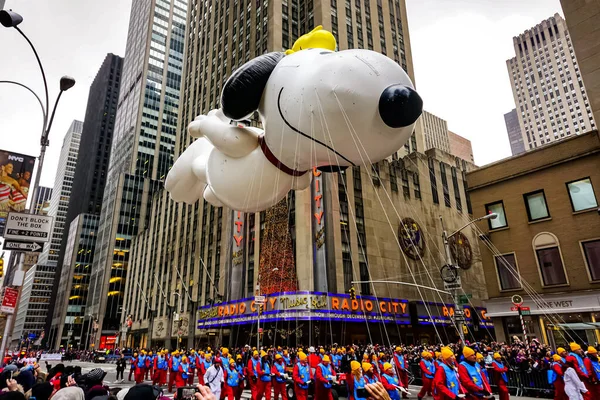 Snoopy balonu her yıl düzenlenen Macy 'nin Şükran Günü geçit töreninde havada süzülüyor. Arka planda Radyo Müzik Salonu var. Manhattan, New York, ABD - 27 Kasım 2014.