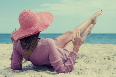 kırmızı şapkalı yasaktır kız sahilde yaz aylarında yatıyor.