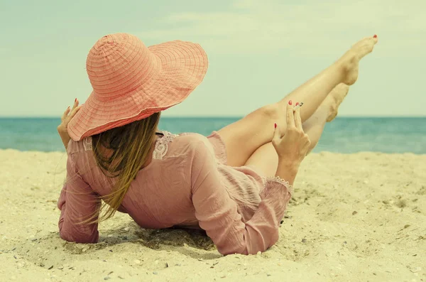 kırmızı şapkalı yasaktır kız sahilde yaz aylarında yatıyor.