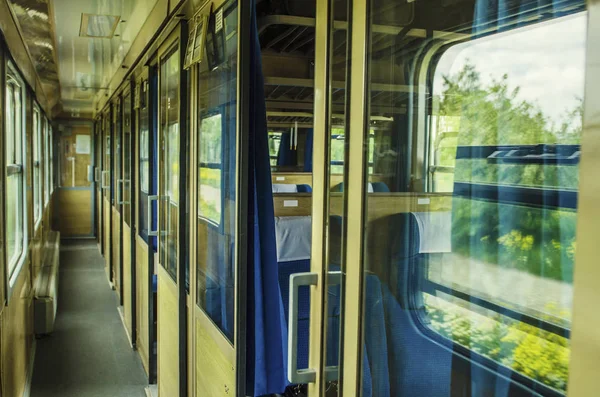 empty car of the train of the long-distance message. Inside of old public railway train cabin with seats, handrails, fan and interior in vintage style service for passenger transpor