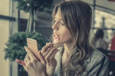 modern iş kadını öğle anda makyaj yapıyor