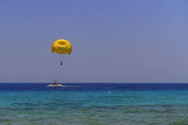 Sarı bir paraşütle uçan paraşütçü