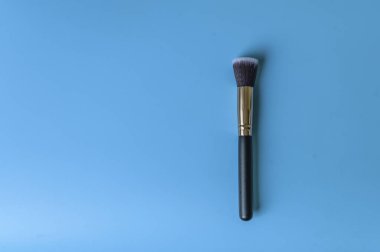 Mavi arka planda makyaj fırçası