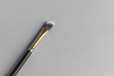 Gri arka planda makyaj fırçası