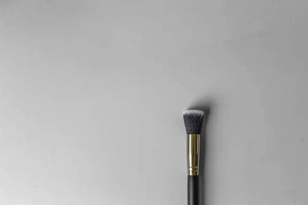 Make-up borstel op een grijze achtergrond — Stockfoto