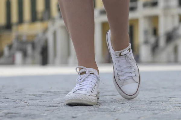 Крупный план женских ног в белых кроссовках — стоковое фото