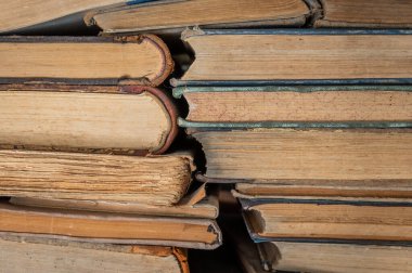 Bir yığın eski antika kitap. Antika kitapları sıcak yönlü ışıkta birikir.