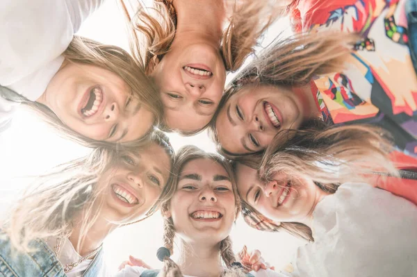 Teenage school friends smiling to camera. Diverse group of sporty attractive girls enjoy time together, smiling people in sportswear, happy friends looking at camera. Well being, wellness concept