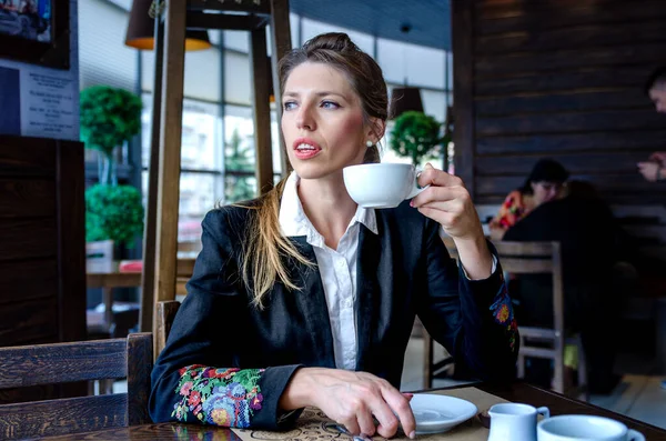 Business woman drinking coffee in a cafe. Portrait of young woman drinking tea.