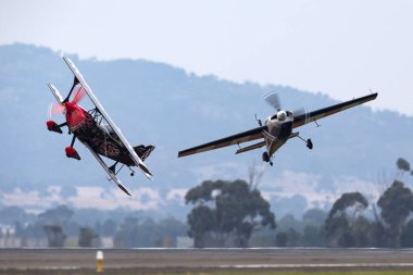 Avalon, Australia - February 26, 2013: Melissa Andrzejewski flying an Edge 540 aerobatic aircraft with Skip Stewart flying in Pitts Special S-2 aircraft.  clipart