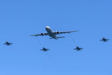 RAAF Williams, Point Cook, Australia - March 2, 2014: Royal Australian Air Force (RAAF) Airbus KC-30A Multi Role Tanker Transport Aircraft A39-003 refueling four McDonnell Douglas F/A-18 Hornet fighter aircraft. clipart