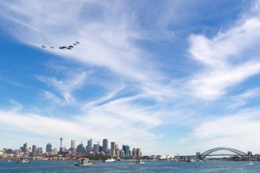 Sydney, Australia - October 5, 2013: Formation of eight Royal Australian Air Force (RAAF) aircraft flying over Sydney Harbor with Navy ships on the water. clipart