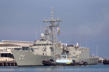 Melbourne, Avustralya - 12 Haziran 2015: HMAS Melbourne (FFG 05) Avustralya Kraliyet Donanması güdümlü füze fırkateyni Melbourne, İstasyon İskelesi 'nde römorkör botlarının yardımıyla.