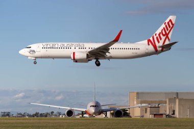 Melbourne, Avustralya - 23 Haziran 2015: Virgin Australia Airlines Boeing 737-800 uçağı Melbourne Havaalanına inmek üzereyken bir Jetstar Airways Boeing 787 kalkış için bekliyor.