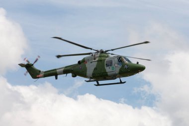 RAF Waddington, Hughnshire, İngiltere - 5 Temmuz 2014: Westland Lynx AH.7 Helicopter XZ184 İngiliz Ordusu Hava Kuvvetleri parçalı bulutlu bir gökyüzüne karşı uçuyor. 