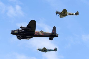 RAF Waddington, the UK - 5 Temmuz 2014: Royal Air Force (RAF) Battle of Britain Memorial Flight Avro Lancaster bombardıman uçağı PA474 iki Supermarine Spitfire avcı uçağı ile birlikte.