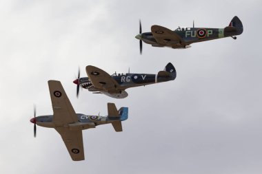 Temora, Avustralya - 2 Kasım 2013: Commonwealth Aircraft Corporation CA-18 Mustang (Kuzey Amerika P-51D Mustang) iki Supermarine Spitfire ile uçuş formasyonunda.