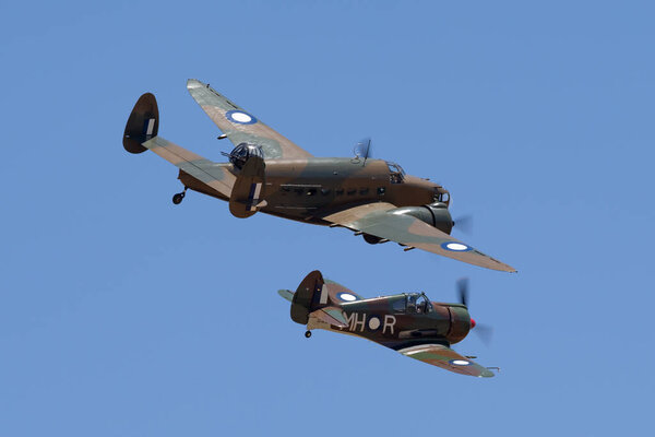 Темора, Австралия - 2 ноября 2013 года: Локхид Хадсон двухмоторный легкий бомбардировщик и прибрежные разведывательные самолеты, летящие в строю с истребителями Commonwealth Aircraft Corporation Boomerang
.