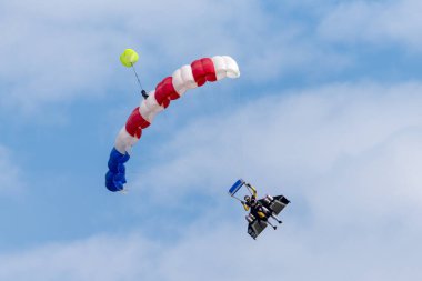 Payerne, Switzerland - August 29, 2014: Yves Rossy also know as Jetman parachutes to the ground after flying with his jet powered wing on his back. 