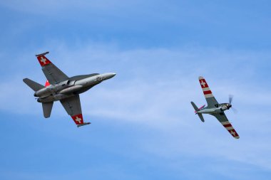 Payerne, İsviçre - 30 Ağustos 2014: Eski İsviçre Hava Kuvvetleri Morane-Saulnier D-3801 savaş uçağı, İsviçre Hava Kuvvetleri McDonnell Douglas F / A-18C Hornet çok delikli savaş uçağı ile uçuyor.