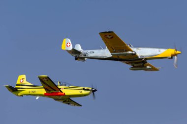 Payerne, Switzerland - September 6, 2014: Former Swiss Air Force F+W C-3605 Schlepp target towing aircraft used to train pilots in aerial gunnery flying in formation with a Pilatus PC-9 that is used in the same role today.