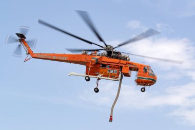 Bundoora, Avustralya - 30 Aralık 2019: İtfaiyeci Erickson Air Crane helikopteri küçük bir gölden su doldurduktan sonra havalandı.