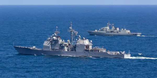 Sydney, Avustralya - 11 Ekim 2013: USS Chosin (CG-65) Ticonderoga sınıfı güdümlü füze kruvazörü ve Avustralya Kraliyet Donanması Anzak sınıfı firkateyni HMAS Parramatta denizde yelken açıyor. 