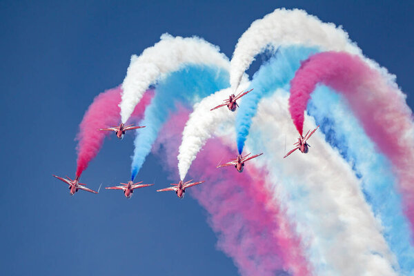 RAF Fairford, Gloucestershire, UK - July 13, 2014: Royal Air Force (RAF) Red Arrows formation aerobatic display team flying British Aerospace Hawk T.1 Jet trainer aircraft.