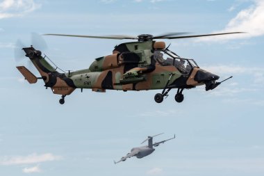 Avalon, Avustralya - 27 Şubat 2015: Avustralya Ordusu Eurocopter Tiger ARH Silahlı keşif helikopteri ve bir Kraliyet Avustralya Hava Kuvvetleri (RAAF) Boeing C-17A kargo uçağı arka planda uçuyor. 