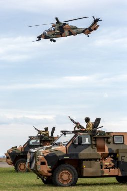 Avalon, Avustralya - 27 Şubat 2015: İki Avustralya Ordusu Zırhlı Personel Taşıyıcı Gemisi (APC) ve bir Eurocopter Tiger helikopteri hava desteği sağlamaktadır. 